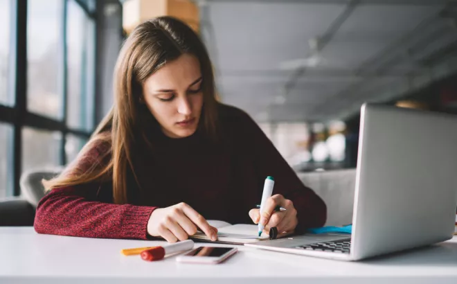 Een student die aan het studeren is aan een tafel