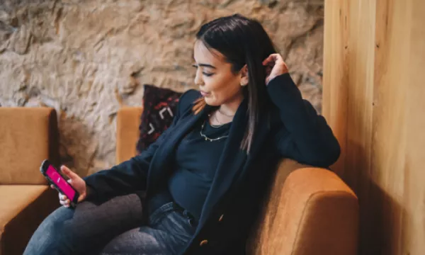 Une jeune fille qui cherche un job étudiant sur son smartphone