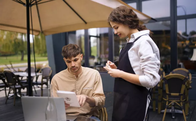 Une jeune femme prend la commande d'un client