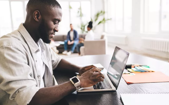 Man is aan het typen op zijn laptop