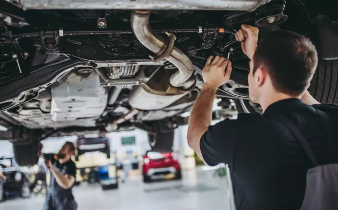 Twee monteurs sleutelen aan een auto