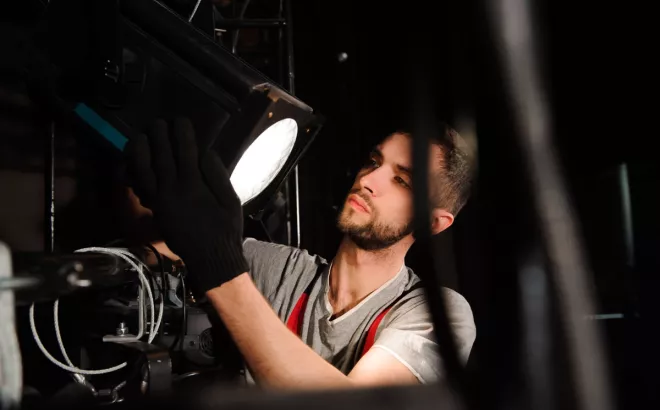 Een bijverdiener installeert een lamp in de muzieksector