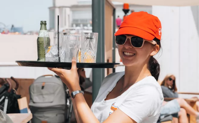 Une jeune femme travaillant en flexi-job dans le secteur de l'horeca.