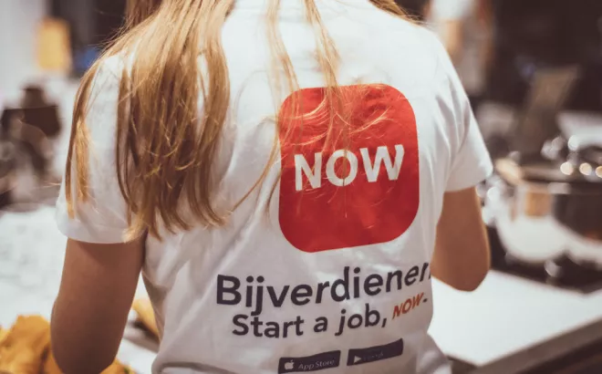 Een bijverdiener met een NOWJOBS T-shirt is druk aan de slag
